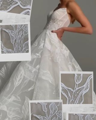 Svatební šaty jsou jedinečné svým odvážným designem, který se zaměřuje na velké, výrazné květiny a listy zdobené lesklými...